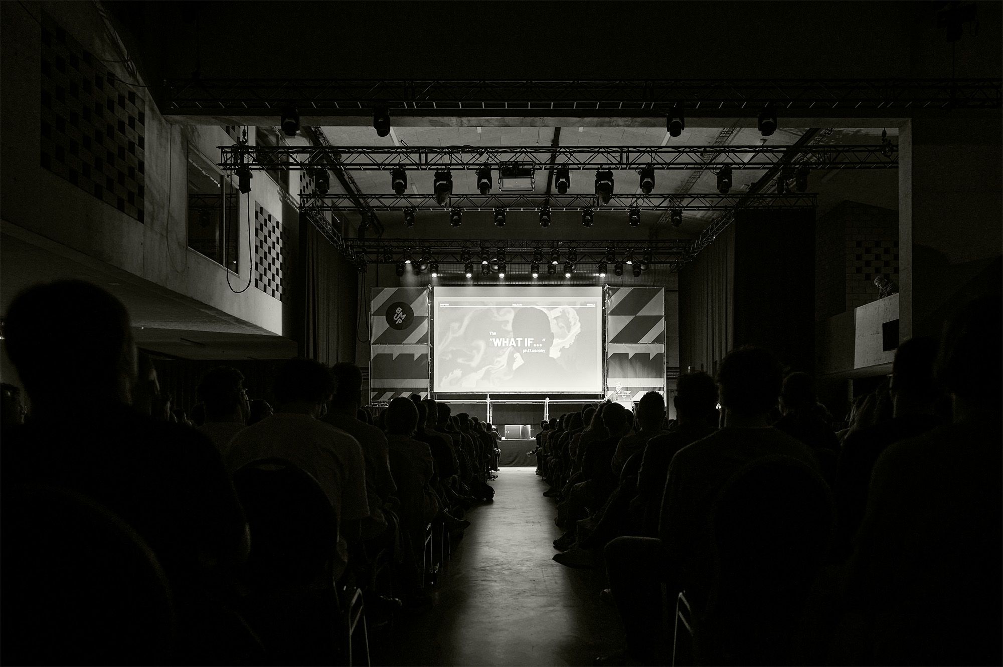 Front view of the stage, the words 'what if' are displayed on the projection